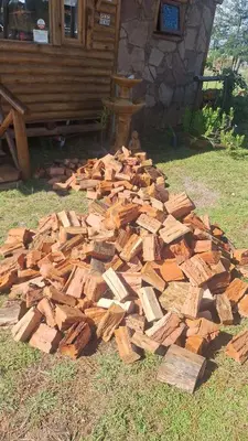 a pile of wood on the ground in front of a house at Cabaña La Fortaleza Villa Yacanto in Villa Yacanto