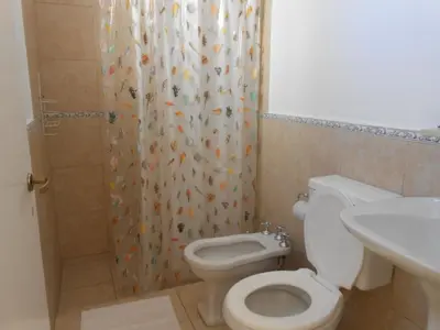 a bathroom with a toilet and a shower curtain at Alta Gracia Hostel in Alta Gracia