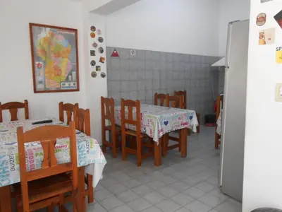 a dining room with two tables and wooden chairs at Alta Gracia Hostel in Alta Gracia