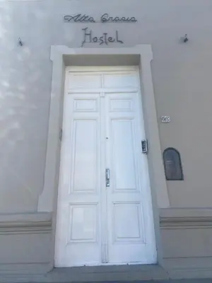 a white door in a building with a sign above it at Alta Gracia Hostel in Alta Gracia