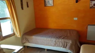 a small bed in a room with a window at Cabañas walcarpi in Villa Ciudad Parque