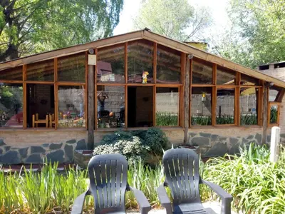 two chairs sitting in front of a greenhouse at Cabañas walcarpi in Villa Ciudad Parque