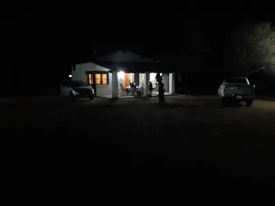 a house at night with two cars parked in front at Cabañas La Victoria, Las Calles, Traslasierras, Córdoba in Las Rabonas