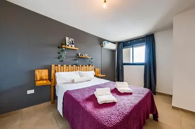 a bedroom with a large bed with a purple blanket at ALTOS DE COLON in Cordoba