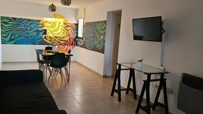 a living room with a table and a tv on the wall at ALTOS DE COLON in Cordoba