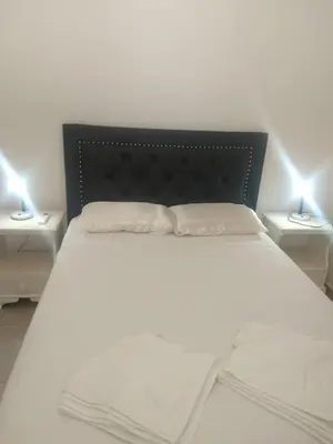 a bedroom with a white bed with two night stands at Zona residencial frente al lago! in Villa Carlos Paz