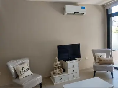 a living room with two chairs and a flat screen tv at Zona residencial frente al lago! in Villa Carlos Paz