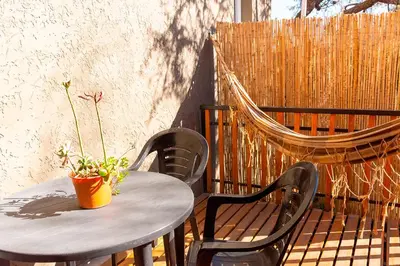 a table with two chairs and a potted plant on a patio at La Cuyanita - Complejo de cabañas in Merlo