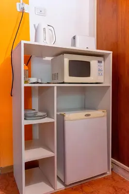 a white cabinet with a microwave and a refrigerator at La Cuyanita - Complejo de cabañas in Merlo
