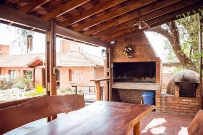 an outdoor patio with a wooden table and a fireplace at La Cuyanita - Complejo de cabañas in Merlo