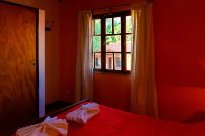 a red room with a bed with a window at La Cuyanita - Complejo de cabañas in Merlo