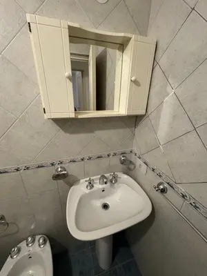 a bathroom with a sink and a mirror and a toilet at Departamento EL QUINTANAR 2 in Cordoba