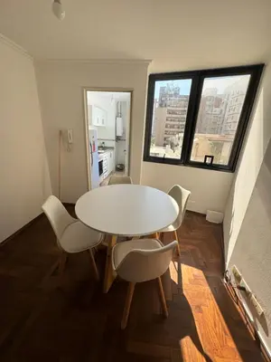 a white table and chairs in a room with windows at Departamento EL QUINTANAR 2 in Cordoba