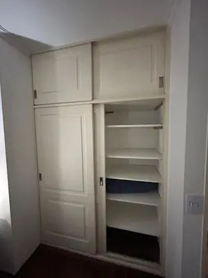 a closet with white doors and shelves in a room at Departamento EL QUINTANAR 2 in Cordoba