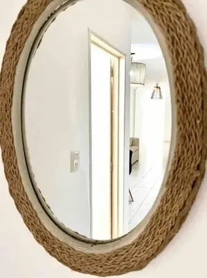 a round mirror on a wall in a room at Departamento Triana in Cordoba