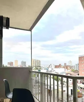 a balcony with a chair and a view of a city at Departamento Triana in Cordoba