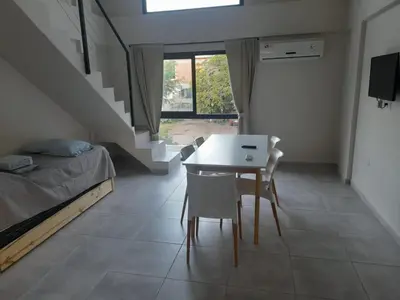 a bedroom with a bed and a table and chairs at Los Gigantes in Villa Carlos Paz