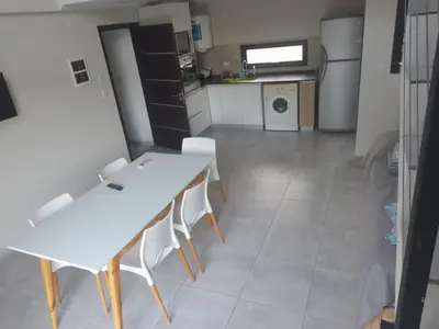 a kitchen with a white table and white chairs at Los Gigantes in Villa Carlos Paz