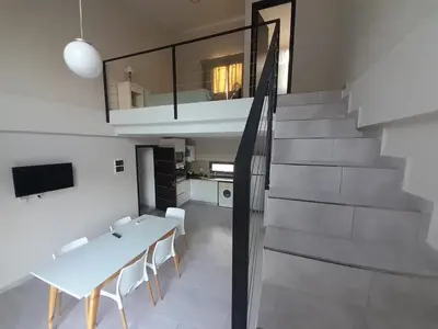 a dining room with a white table and a staircase at Los Gigantes in Villa Carlos Paz