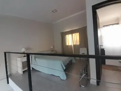 a white bedroom with a bed and a window at Los Gigantes in Villa Carlos Paz