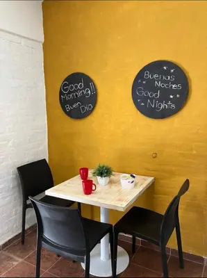 a table and chairs in a restaurant with signs on the wall at Departamentos del Cerro in Cordoba