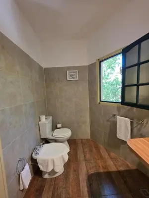 a bathroom with a toilet and a window at Hotel Loma Bola in La Paz