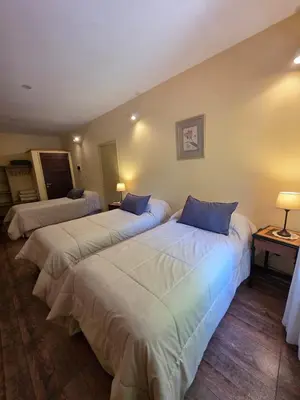 a hotel room with two beds with blue pillows at Hotel Loma Bola in La Paz