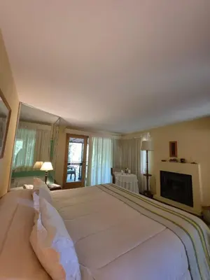 a large white bed in a bedroom with a fireplace at Hotel Loma Bola in La Paz