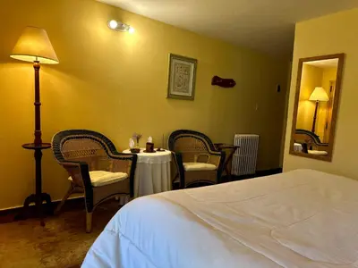 a hotel room with a bed and a table and chairs at Hotel Loma Bola in La Paz