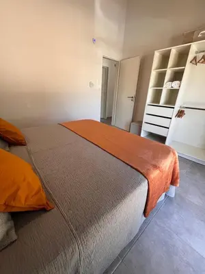a bedroom with a large bed with an orange blanket at Sierras VGB Centro in Villa General Belgrano