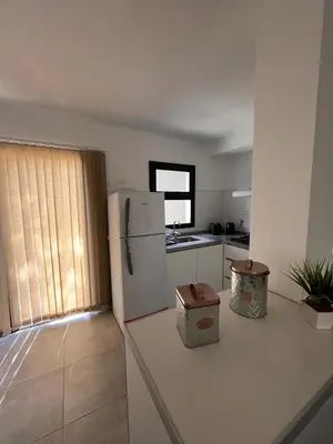 a kitchen with a white refrigerator and a window at Sierras VGB Centro in Villa General Belgrano