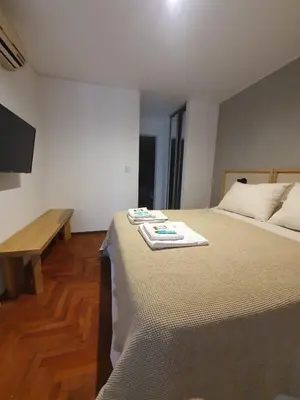 a bedroom with a bed with a table and a television at Locador Nueva Cordoba 5A in Cordoba