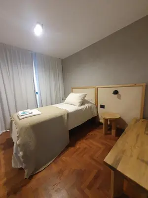 a small bedroom with a bed and a table at Locador Nueva Cordoba 5A in Cordoba