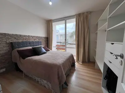 a bedroom with a bed and a large window at Duplex Independencia in Villa Carlos Paz