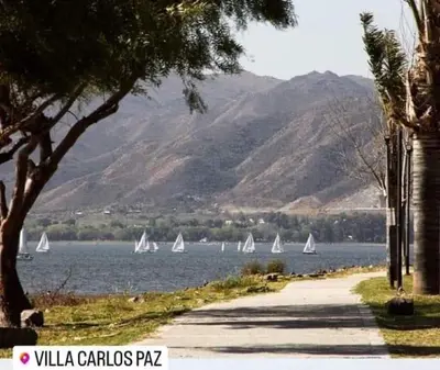 a group of sail boats on a lake with mountains at Duplex Independencia in Villa Carlos Paz