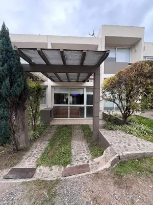 a house with a pergola in front of it at Duplex Independencia in Villa Carlos Paz