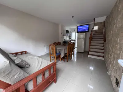 a bedroom with a bed and a table and a kitchen at Duplex Independencia in Villa Carlos Paz