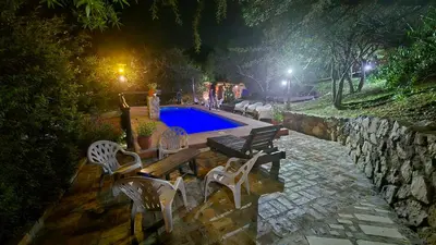 a swimming pool at night with two chairs and a wooden bench at La Pasionaria in La Rancherita