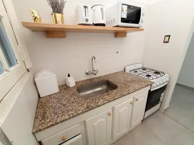 a small kitchen with a sink and a stove at Artigas Confort - Bienes Reales in Cordoba