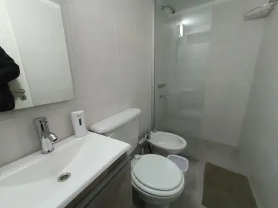 a white bathroom with a toilet and a sink at Artigas Confort - Bienes Reales in Cordoba