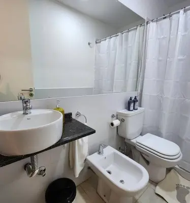 a white bathroom with a sink and a toilet at Loft en Güemes Piso 9 in Cordoba