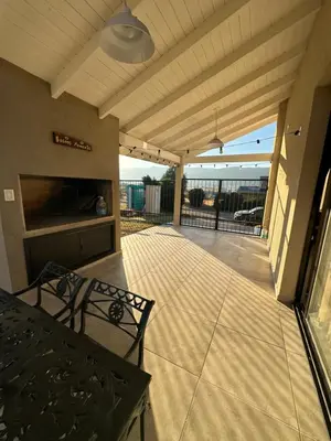 a covered patio with a table and a fireplace at villa marina in Villa General Belgrano