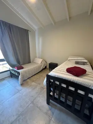 two beds in a room with a window at villa marina in Villa General Belgrano
