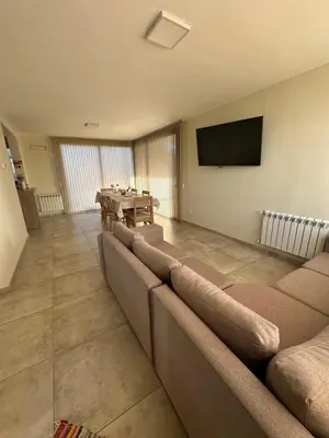 a living room with a couch and a television at villa marina in Villa General Belgrano