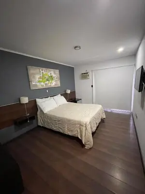 a hotel room with a bed and a flat screen tv at Costalago Suites Hotel in Villa Carlos Paz