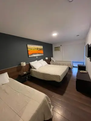 a hotel room with two beds and a wall at Costalago Suites Hotel in Villa Carlos Paz