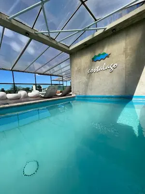 a pool of water with a sign on the side of a building at Costalago Suites Hotel in Villa Carlos Paz