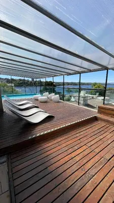 a wooden deck with a pavilion with a view of the water at Costalago Suites Hotel in Villa Carlos Paz