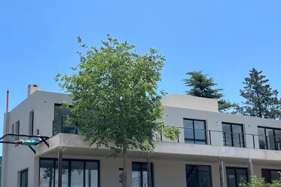 a building with a tree in front of it at Lago de montaña in Villa Carlos Paz