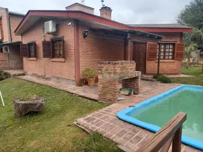 a house with a swimming pool in the yard at Cabañas Aromas Serranos in Alta Gracia